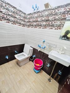 a bathroom with a toilet and a sink at Bala ji guest house in Vrindāvan +1 photo