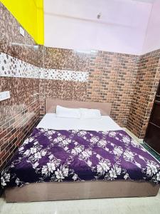a bedroom with a bed in a brick wall at Bala ji guest house in Vrindāvan