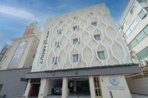 un edificio con una fachada curva y un reloj en ella en From H About Hotel Chungju, en Chungju