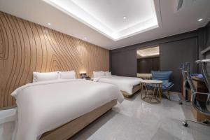 una habitación de hotel con dos camas y un escritorio en From H About Hotel Chungju, en Chungju