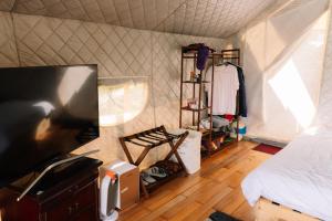 a bedroom with a bed and a tv in a tent at Danny Glamping Farm in Bao Loc