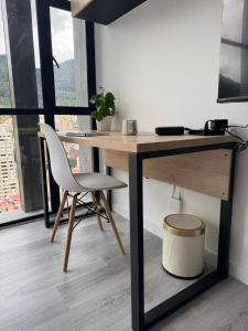 escritorio y silla en una habitación con ventana en Modern apartment with a beautiful panoramic view, en Bogotá