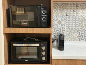a microwave in a wooden cabinet with a toaster oven at Eiko的樓仔厝 台南包棟民宿 in Ching-chung-san-ts'un