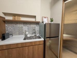 a kitchen with a sink and a refrigerator at Eiko的樓仔厝 台南包棟民宿 in Ching-chung-san-ts'un