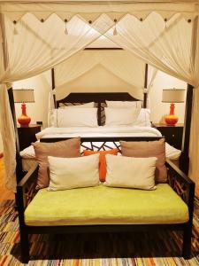 a bed with a green bench in a room at Casa Acantilado Oslob - 3BR in Oslob
