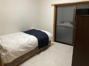 a small bedroom with a bed and a closet at 民泊絹家 in Izume