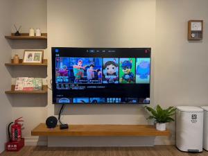a flat screen tv hanging on a wall at Eiko的樓仔厝 台南包棟民宿 in Ching-chung-san-ts'un