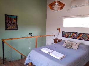 a bedroom with a bed with two towels on it at Malvón in Cafayate