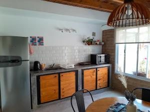 a kitchen with a stainless steel refrigerator and a table at Malvón in Cafayate