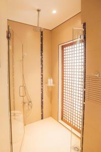a bathroom with a shower and a glass door at Casa Acantilado Oslob - 3BR in Oslob