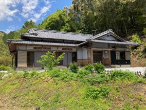a small house on top of a hill at 民泊絹家 in Izume