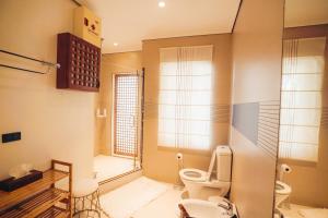 a bathroom with a toilet and a window at Casa Acantilado Oslob - 3BR in Oslob +7 photos