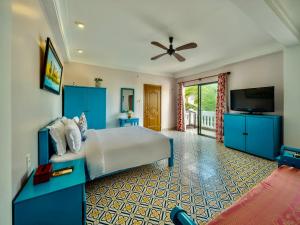 Grace Boutique Resort في موي ني: غرفة نوم مع سرير وتلفزيون بشاشة مسطحة