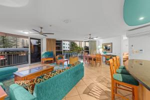 a living room with a couch and a table at Brisbane Road Apartments Mooloolaba in Mooloolaba