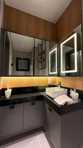 a bathroom with a sink and a mirror at Flat moderno e aconchegante Holambra in Holambra +31 photos