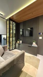 a bedroom with a large bed and a flat screen tv at Flat moderno e aconchegante in Holambra