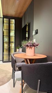 a table and chairs with a potted plant on it at Flat moderno e aconchegante in Holambra