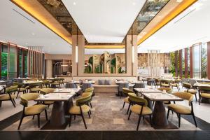 ラブハン・バジョにあるCrowne Plaza Labuan Bajo by IHGのテーブルと椅子のあるレストランのイメージ