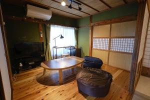 - un salon avec une table et un pouf dans l'établissement Ichiya - Vacation STAY 83331, à Shimosato