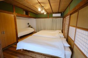 - 2 lits dans une petite chambre aux murs verts dans l'établissement Ichiya - Vacation STAY 83331, à Shimosato