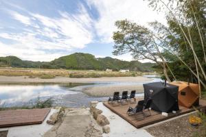 un groupe de chaises assises sur une terrasse à côté d'une rivière dans l'établissement Ichiya - Vacation STAY 83331, à Shimosato