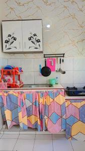 a kitchen with a counter top with colorful tiles at Villa Highland 9O Berastagi View in Berastagi