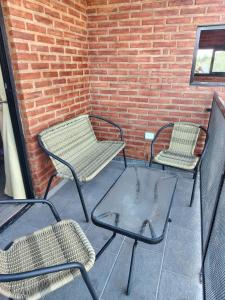 3 chaises et une table sur une terrasse dans l'établissement Panorámica Sierras, à Villa Carlos Paz