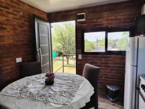 a dining room with a table and a refrigerator at Panorámica Sierras in Villa Carlos Paz