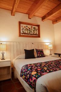 a bedroom with a bed and a painting on the wall at Hotel Puerta de Piedra in Tapalpa