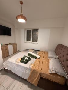 a bedroom with a bed with two green towels on it at Apartament Bella in Craiova
