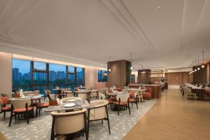a restaurant with tables and chairs and windows at Hilton Garden Inn Lanzhou Anning in Lanzhou