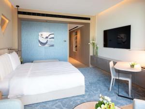 ein Hotelzimmer mit einem Bett und einem Tisch in der Unterkunft La Cigale Hotel Managed by Accor in Doha + 155 Fotos