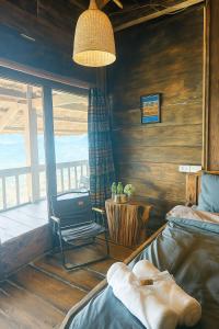 Bắc YênにあるNơi Ấy Homestayのベッド2台、椅子、窓が備わる客室です。