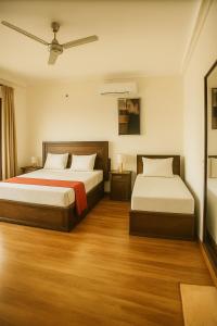 two beds in a room with wooden floors at Pearl Paradise Villa in Awariwatta +19 photos