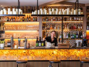 a woman behind the bar of a liquor store at Novotel Megève Mont-Blanc in Megève