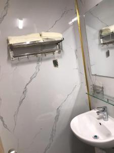 a white bathroom with a sink and a mirror at Simple House-Simple Life in Long Xuyên