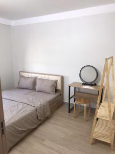 a bedroom with a bed and a table and a desk at Simple House-Simple Life in Long Xuyên