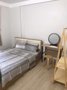 a bedroom with a bed and a table and a chair at Simple House-Simple Life in Long Xuyên