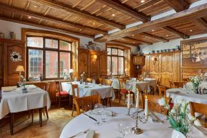 オットロットにあるHotel Restaurant L'Ami Fritzの白いテーブルと椅子、木製の天井が備わるレストラン