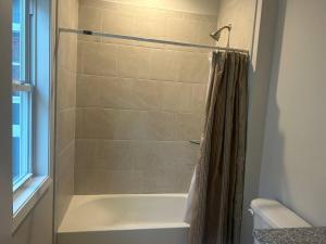 a bathroom with a shower with a white tub at The Magnolia Suite in Oxford