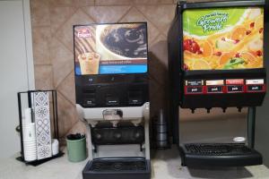 een koffiezetapparaat en een drankautomaat naast een koffiezetapparaat bij Super 8 by Wyndham Savannah in Savannah