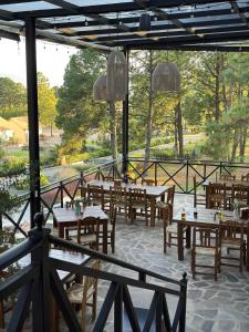 a restaurant with tables and chairs in a park at Hotel Puerta de Piedra in Tapalpa +18 photos