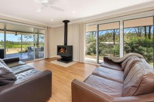 a living room with a couch and a fireplace at Rose at the Vineyard in Pokolbin