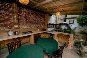 a patio with a green table and chairs and a brick wall at DANDELION - Unawatuna in Unawatuna