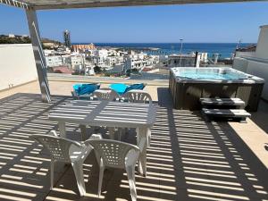 a patio with a table and chairs and a hot tub at Clara Grace sea view in Leuca