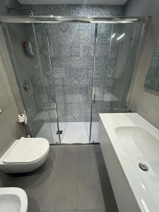 a bathroom with a shower and a toilet and a sink at Clara Grace sea view in Leuca