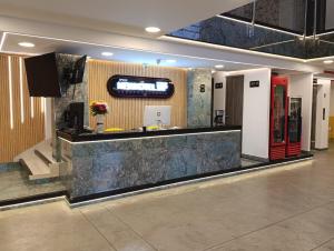 a lobby with a counter with a tv on the wall at New Hotel Vip in Bogotá