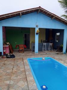 a blue house with a swimming pool in front of it at Recanto Barcelos de Mel com piscina e churrasqueira in Camamu