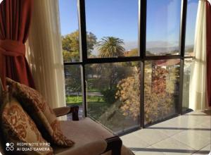 a living room with a large window looking out at the garden at Departamentos de Altura in Tarija
