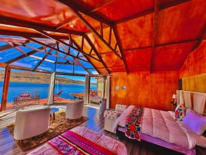 a bedroom with a bed and a view of the water at Titicaca Samay Lodge Perú in Puno